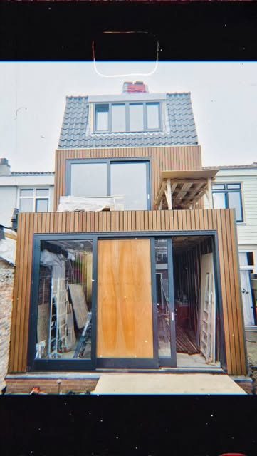 Moderne houten aanbouw met grote glazen pui